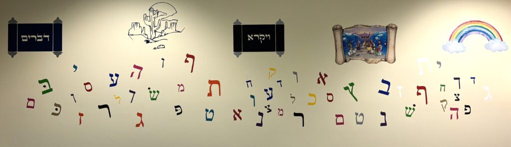 Hebrew letters and decorative pictures on a class room wall.